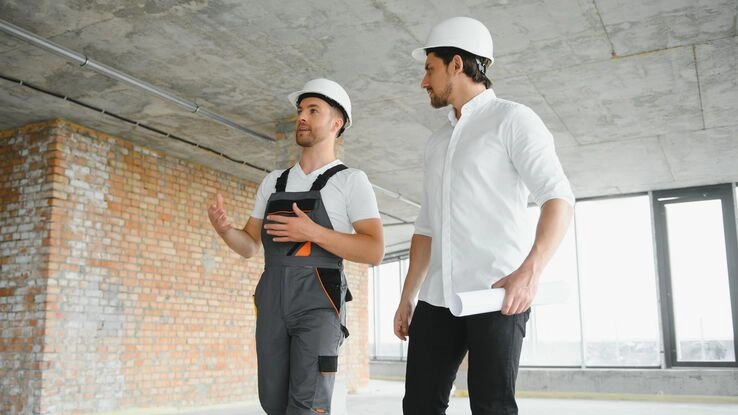 Zwei Männer diskutieren im Rohbau.