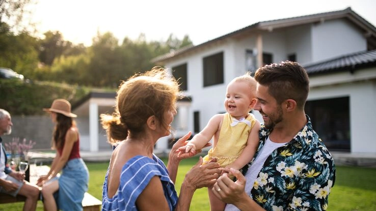 Eine Familie erfreut sich im Garten Ihres Neubaus