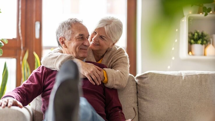 Das Foto zeigt ein Paar auf einem Sofa. Es steht sinnbildlich für das Thema Wohnen auf Zeit eine Übergangslösung.