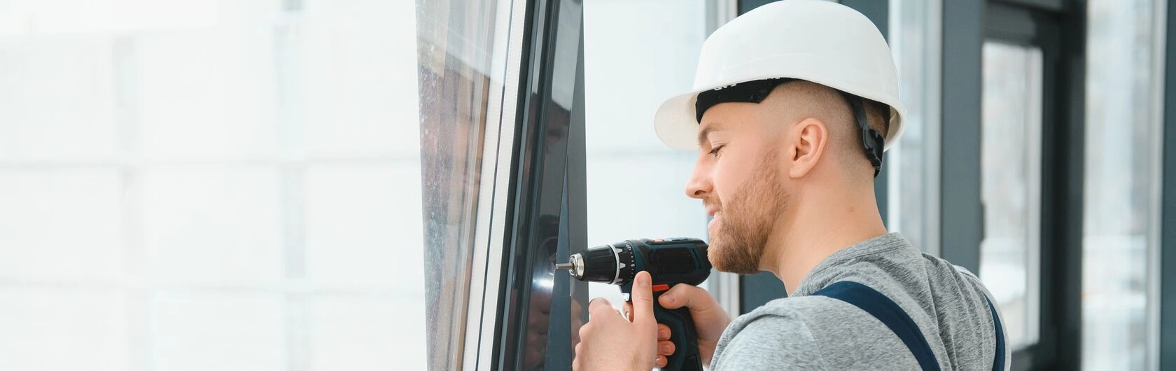 Ein Mann tauscht die Fenster aus, um die Energiebilanz zu verbessern.