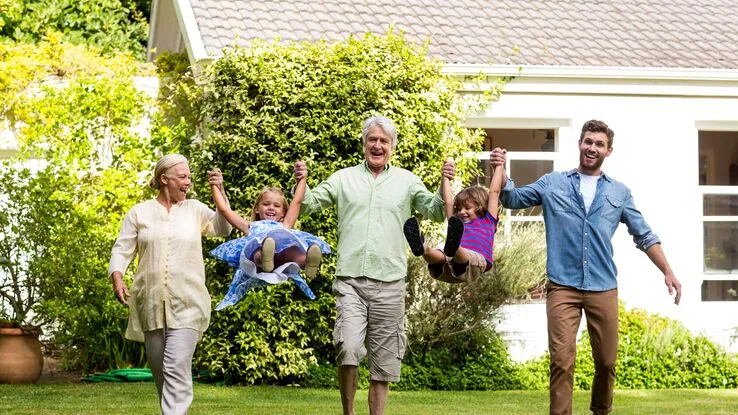 Eine Familie in einem Mehrgenerationenhaus habt Spaß in ihrem Garten.