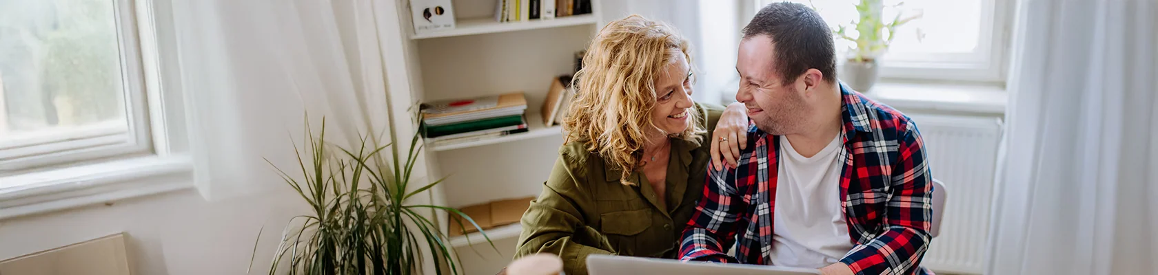 Zwei Personen informieren sich im barrierefrei aufbereiteten Bereich zu Baufinanzierung und Immobilien.
