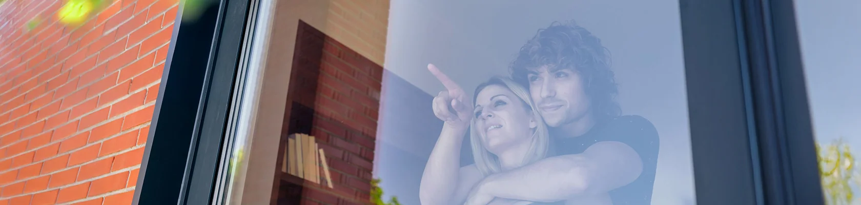 Ein Pärchen schaut aus dem Fenster.