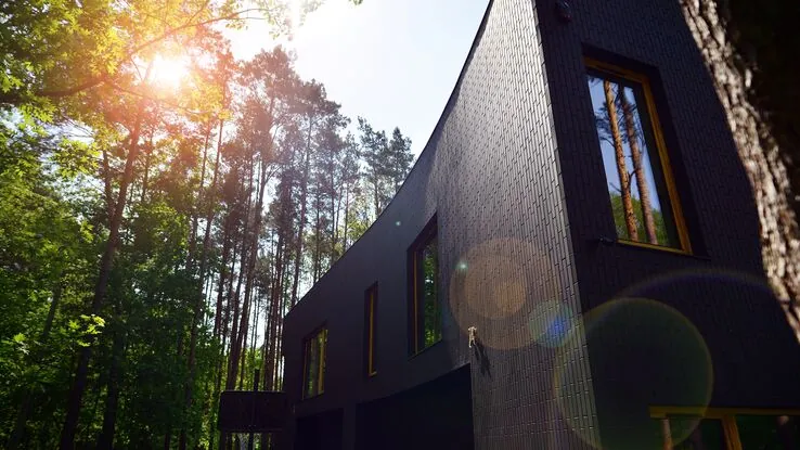 Das Foto zeigt ein Haus in einem Wald um vor der Sonne geschützt zu sein.