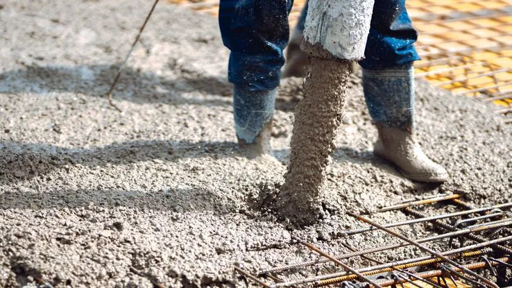 Das Foto zeigt einen Bauarbeiter beim Betonieren. Er steht sinnbildlich für das Thema Selbstheilender Beton.