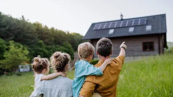 Eine Familie vor einem Hause im Grünenen