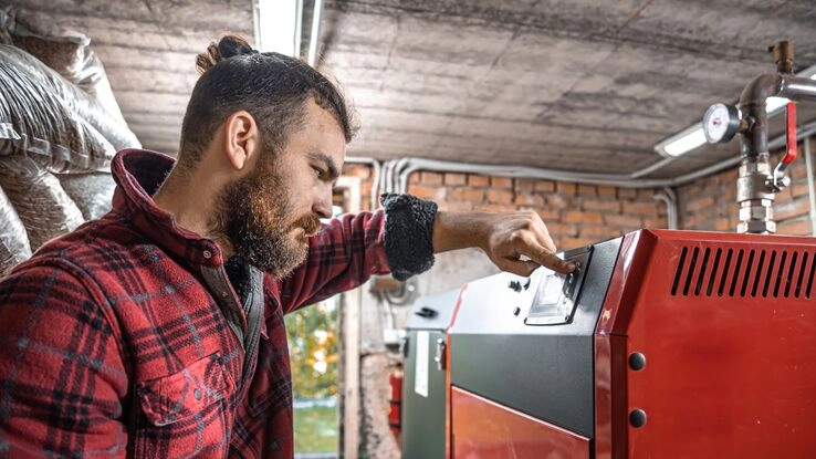 Ein Handwerker prüft die Heizungsanlage.