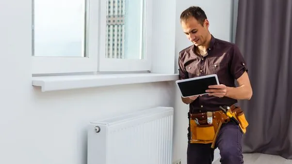 Ein Handwerker beim Thermostat einrichten